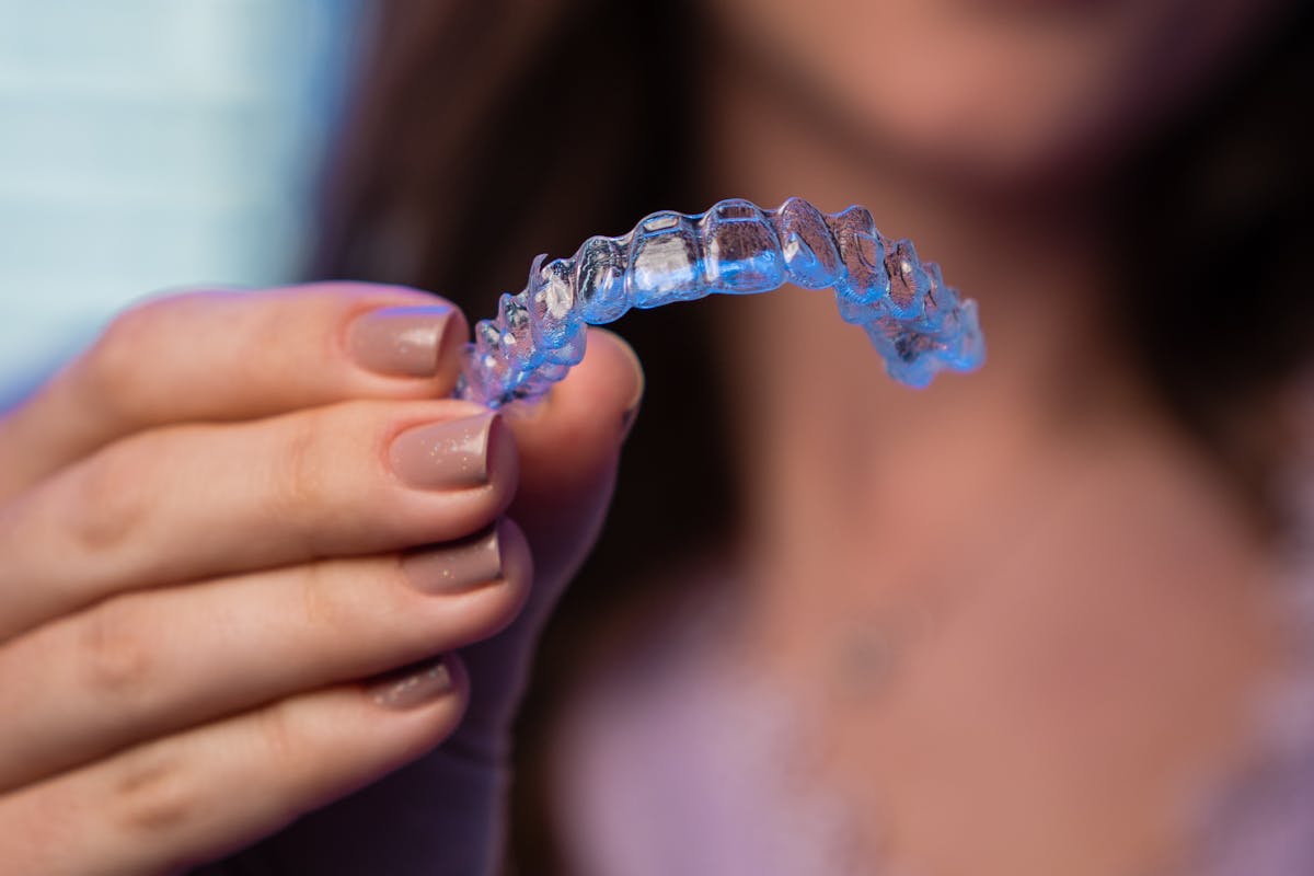 Person Holding Clear Orthodontic Aligner