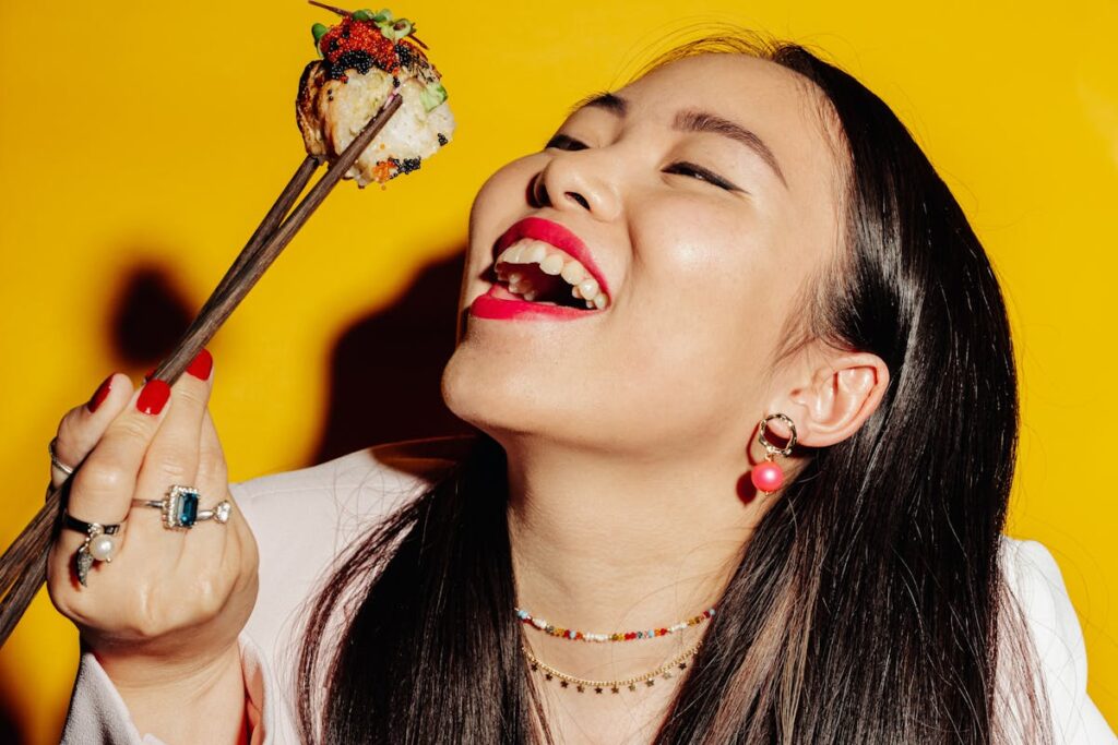 Woman with Open Mouth Holding Wooden Chopsticks with Maki