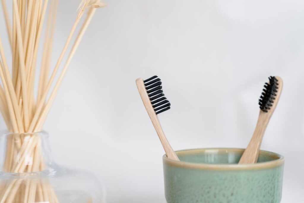 Wooden Toothbrushes in a Green Ceramic Cup