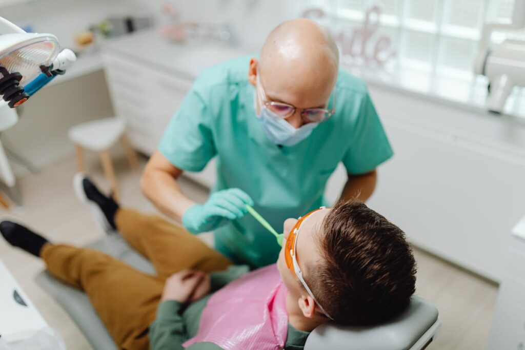 A Dentist Checking the Teeth of his Patient