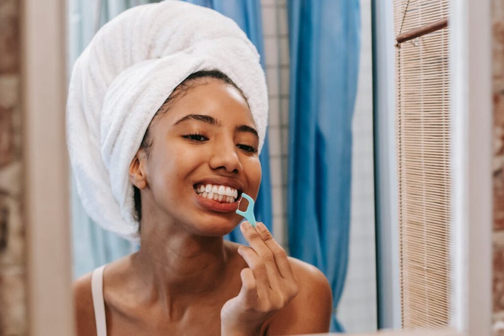 Ethnic woman cleaning teeth with dental floss