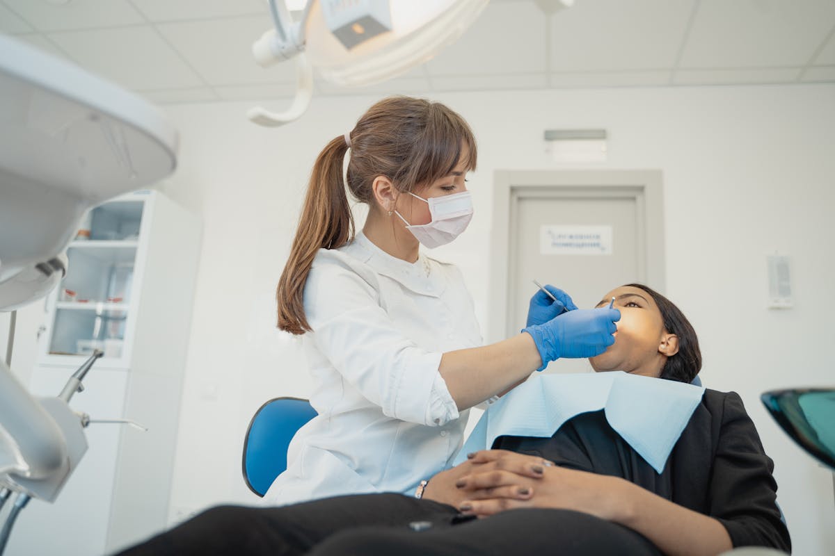 Woman in White Long Sleeve Shirt Checking the Teeth