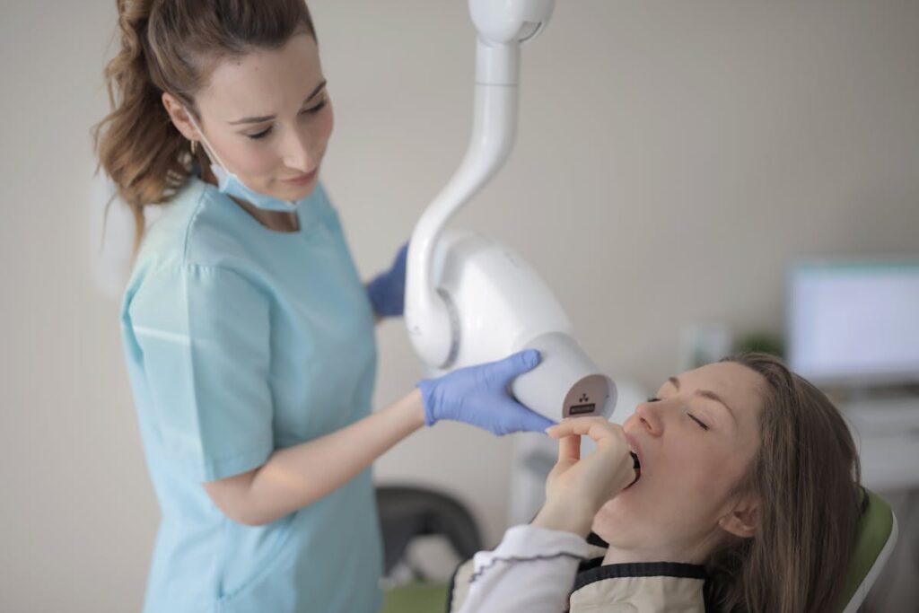 Young female dentist using modern medical equipment