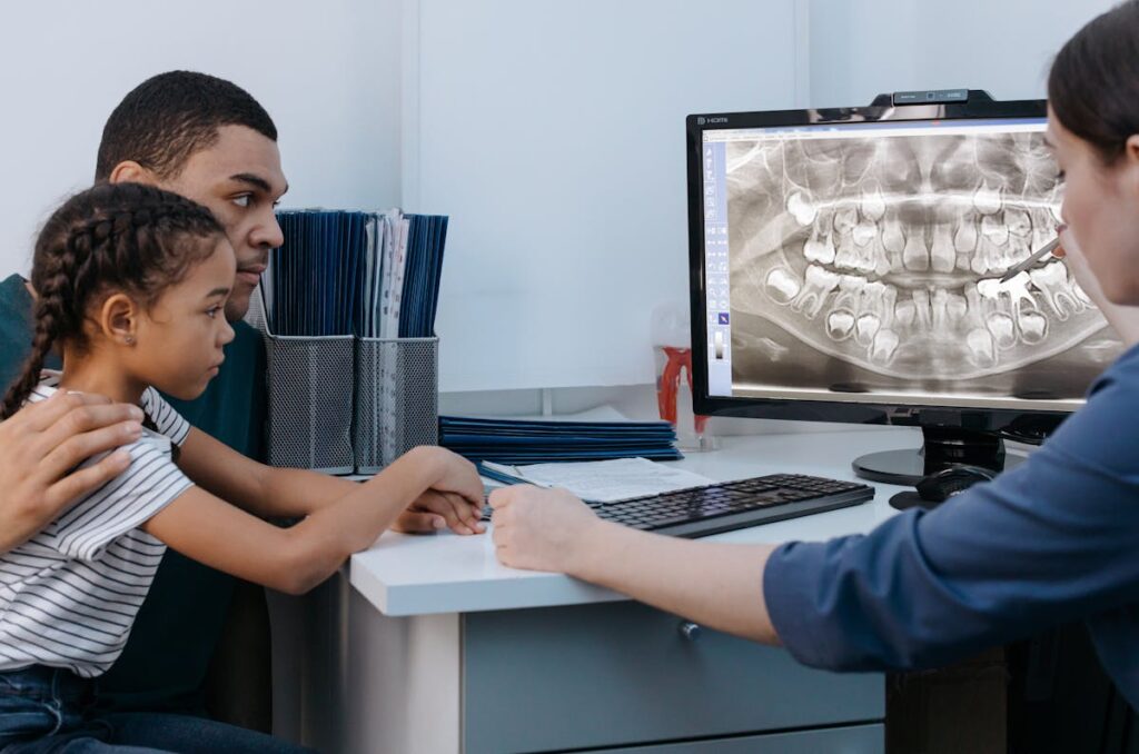 A Man and a Girl Having a Dental Consultation with a Dentist