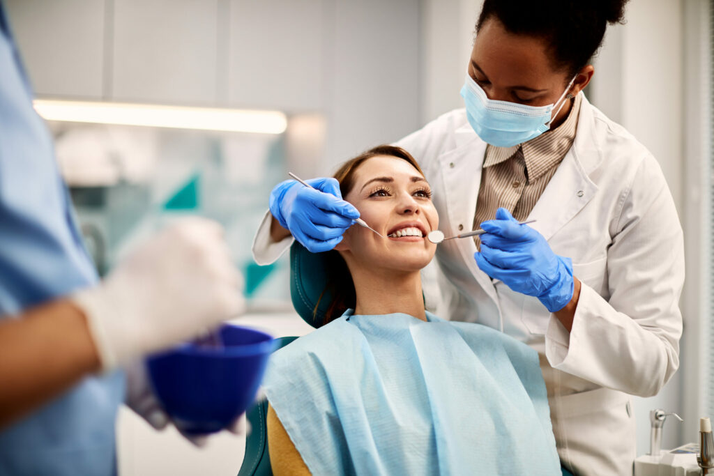 Young smiling woman having dental exam at dentist's office.