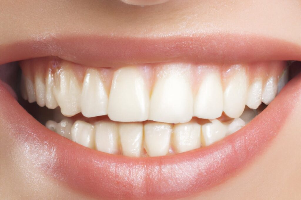 A detailed close-up of a perfect set of white teeth and lips in a bright smile.