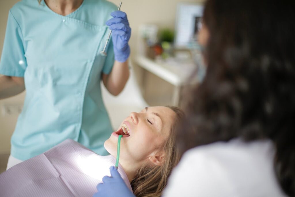 Dentist examining patient in clinic for dental checkup with focus on oral hygiene and care.