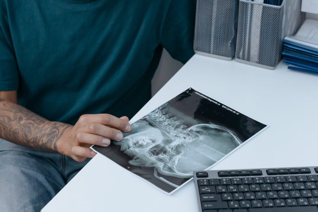 A person examines a dental x-ray in a clinic, showcasing odontology in detail.