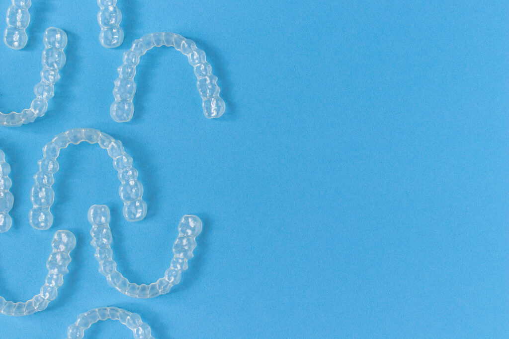Invisalign braces or invisible retainer on blue background