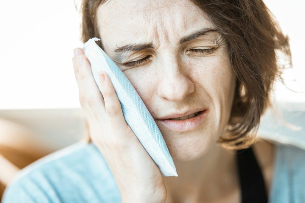 a-woman-putting-cold-compress-on-her-face